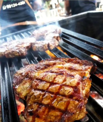 Corte de carne dourando na grelha