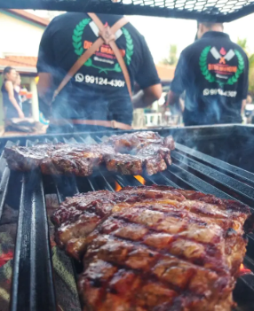 Preparo de carnes na churrasqueira durante evento